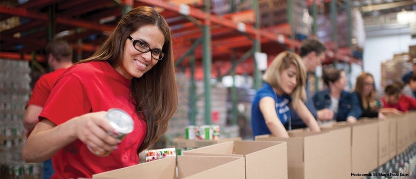 Volunteers placing items in boxes.