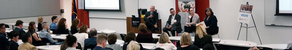 A panel of speakers addresses an audience.