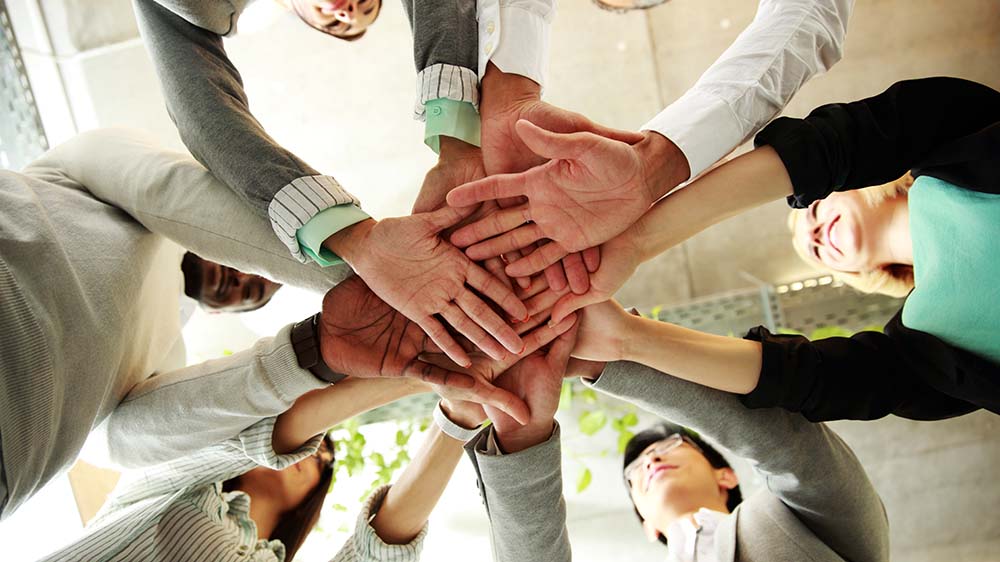 Volunteers bringing hands together