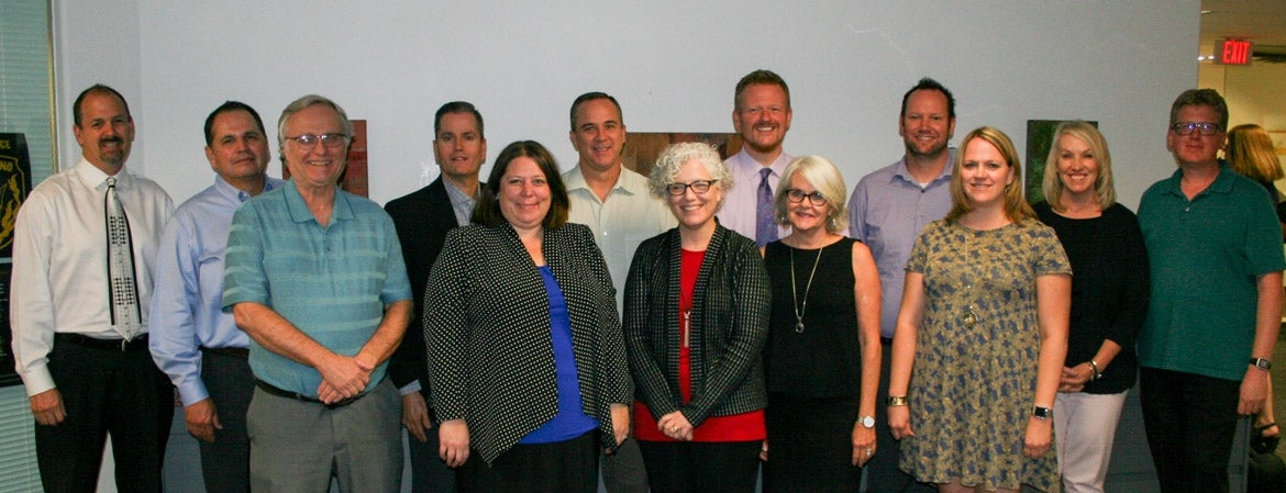 15 new alumni of ASU Lodestar Center for Philanthropy and Nonprofit Innovation's Nonprofit Executive Leadership Certificate program gather in rows inside a building.