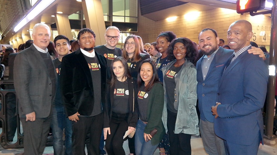 Standing outside a building at night, several Public Allies Arizona members stand next to ASU faculty.